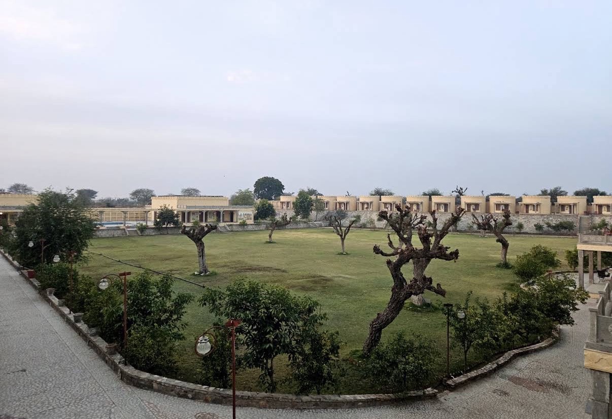 Green lawns and sandstone guest rooms at the venue in Mandawa