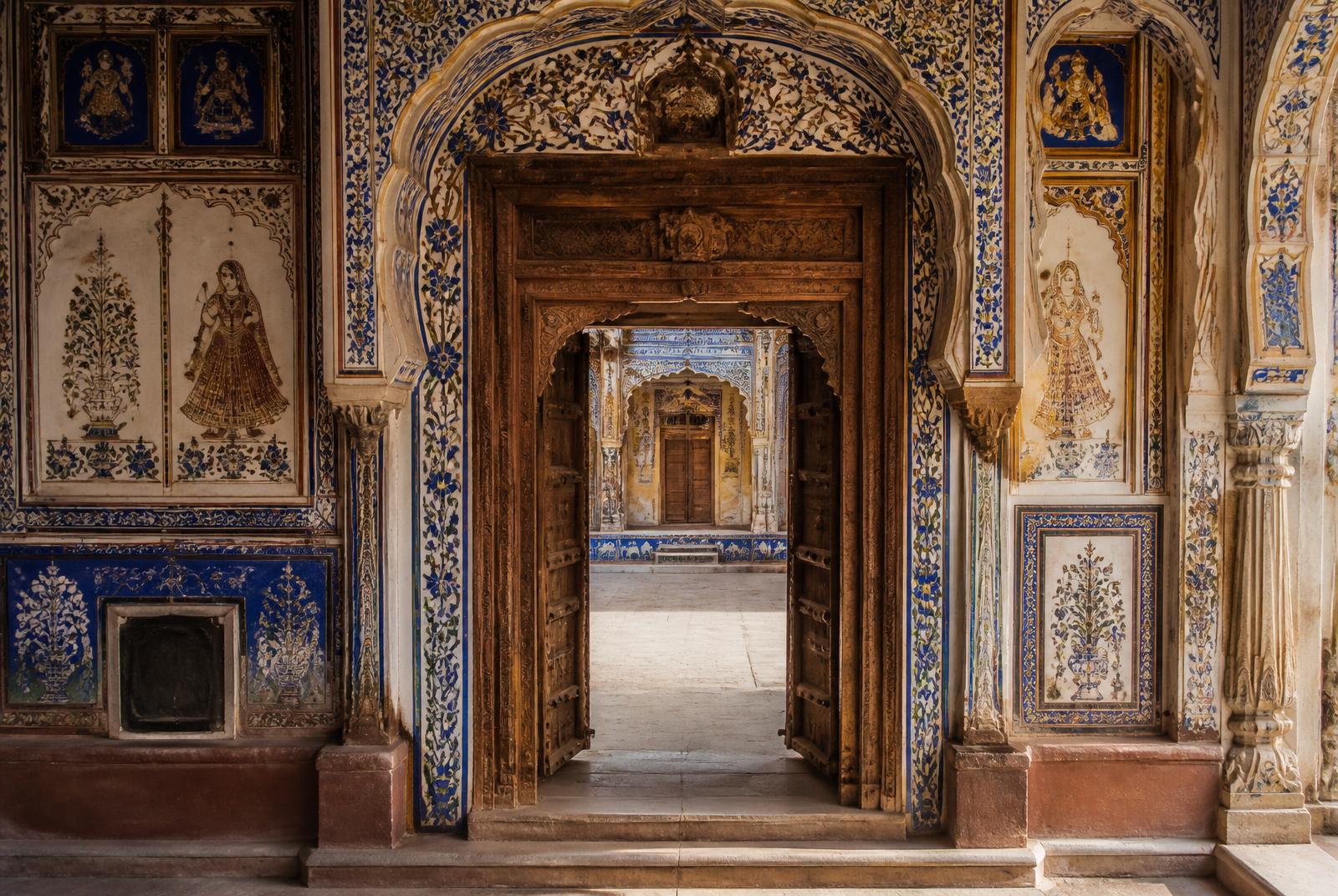 Blue and gold frescoed archway inside a Mandawa haveli courtyard